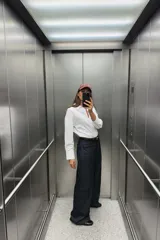 Camisa celeste de popelina de algodón, con cuello solapa, escote pico, manga larga con puños y cierre frontal con botones.