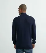 Suéter azul marino de tejido de punto liso, con cuello alto y cremallera corta.