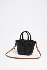 Bolso tipo tote de mimbre color marrón oscuro, con doble asa corta y correa de cuero marrón. Incluye dije circular dorado con letras grabadas.