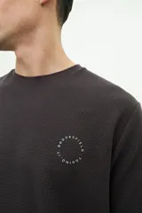 Remera color beige con textura, de manga corta, corte regular y logo estampado en el pecho.