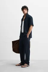 Pantalón azul marino de corte relaxed fit, confeccionado en tejido con mezcla de algodón. Presenta cintura elástica ajustable con cordón, bolsillos frontales y detalle de bolsillo trasero de plastrón.