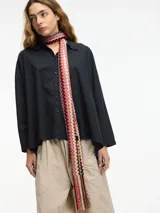 Camisa negra de algodón con botones en la parte delantera y cuello camisero.