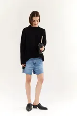 Sweater negro de punto con cuello redondo y corte oversize.