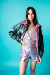 Chaqueta bomber de cuero color marrón, con cuello de piel sintética roja, cierre frontal con cremallera y bolsillos laterales.