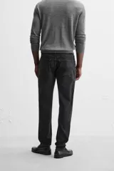 Pantalón de jean azul oscuro, corte slim fit, tiro medio, cinco bolsillos, tejido elástico y efecto lavado.