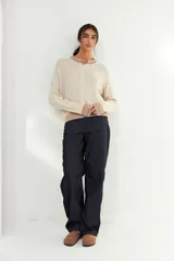 Bomber color crudo de tejido de punto con cierre frontal, cuello, puños y ruedo acanalados con rayas de colores.