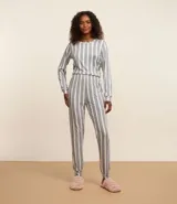 Conjunto de pijama largo compuesto por camisa de mangas largas con escote redondo y pantalón con cintura elástica. Diseño a rayas verticales en gris y blanco.