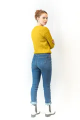 Sweater mostaza de punto acanalado con cuello redondo y mangas largas.