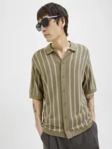 Polo de punto con fit relajado y diseño estructurado. Tejido estilo urbano con cuello tipo camisa, cierre con botones y mangas cortas.