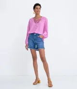 Blusa tipo blusón color rosado, de viscosa, con cuello redondo, manga larga acampanada, pliegues en los hombros, detalle de entredós en el escote y tiras de ajuste con borla.