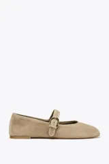 Bailarinas color beige de gamuza con tira sobre el empeine y hebilla dorada.