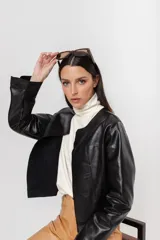 Chaqueta de cuero negra entallada, de largo a la cintura y acabado rústico. Sin forro.