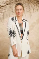 Blazer color crema de lino con bordados florales negros en solapa, mangas y ruedo.