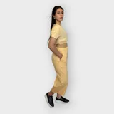 Pantalón color amarillo, de corte amplio y cintura elástica, con largo hasta los tobillos.