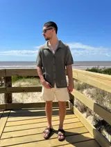 Camisa negra tejida con diseño calado, manga corta y corte regular.