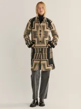 Abrigo jacquard con diseño gráfico en tonos beige y negro, abotonado y de corte largo.