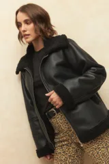 Campera gamulán color crema, con cuello y puños de corderito, cierre frontal con cremallera y bolsillos laterales.