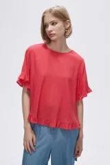 Blusa color coral con cuello redondo y mangas cortas con volados.