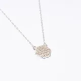 Collar plateado con cadena fina y dije hexagonal con incrustaciones brillantes.