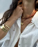 Collar regulable de bronce macizo con cuentas de piedra natural de cuarzo lima y jaspe rojo, y un dije central de labradorita.