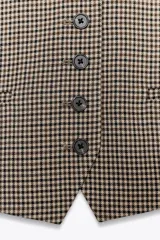 Chaleco de Zara Woman Collection con escote pico y sisa. Tiene falsos bolsillos de vivo en el delantero, tejido combinado a contraste en la espalda y cierre frontal con botones.