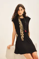 Vestido corto negro de morley con cuello redondo, elástico en la cintura y falda con capas. Incluye medallita marcaria en la espalda.