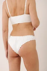 Vedetina color beige de algodón suave con terminaciones fruncidas.