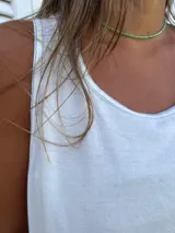Vestido playero blanco de algodón con pespuntes azules, corte recto y sin mangas.