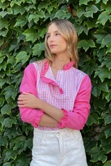 Blusa rosada con mangas largas, cuello con volados y estampado de líneas verticales.