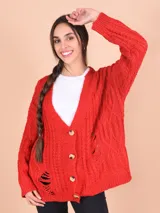 Cárdigan tejido de punto grueso color celeste con diseño trenzado y roturas. Tiene cuello en V, cierre frontal con botones y mangas largas.