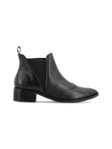 Botín Chelsea de cuero negro con elásticos laterales texturados, taco bajo cuadrado, punta semi-redondeada y detalles oxford. Diseñado en Uruguay y fabricado en Brasil.