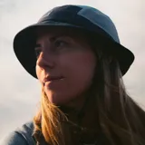 Sombrero tipo bucket de tela deportiva liviana, con paneles laterales microperforados, ajuste elástico en la corona y tira ajustable con tanca.