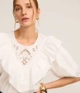 Blusa blanca de tricolina con cuello redondo, mangas cortas abullonadas y detalle de laise en el pecho.