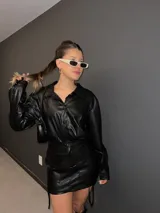 Minifalda negra de ecocuero con cordones laterales ajustables.