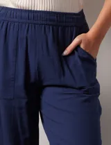 Pantalón blanco de algodón con pretina elastizada, bolsillos inclinados y ruedo lateral con tajo y botones.