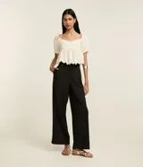 Pantalón negro de vestir, corte wide leg, cintura alta con doble pretina y detalle de remaches.