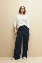 Pantalón de jean azul oscuro, de corte recto y tiro alto, con costuras a la vista.