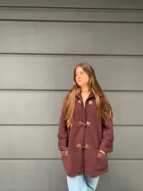 Saco capa bordo de lana con cierre de broches tipo duffle coat y mangas anchas con detalle de tejido trenzado.