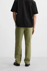 Pantalón verde oliva de corte relaxed fit, confeccionado en tejido de algodón con textura. Tiene cintura elástica ajustable con cordón, bolsillos frontales y un bolsillo trasero de parche.