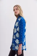 Saco azul eléctrico de viscosa con terminaciones en velvet, bordado con lentejuelas e hilo de lurex. Tiene calce recto, mangas largas y forro interior de jacquard.