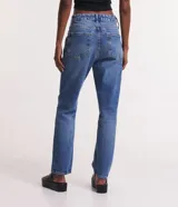 Pantalón de jeans azul de corte slim, tiro alto y cinco bolsillos.