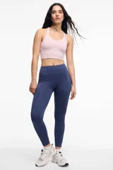 Top deportivo negro con escote en V, breteles finos cruzados en la espalda y copas removibles.