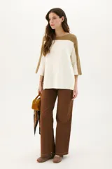 Buzo de punto color beige con mangas 3/4 y detalle bitono en cuello y mangas.