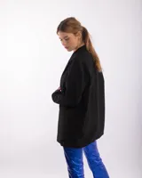 Blazer oversized negro con corte clásico y solapas amplias.
