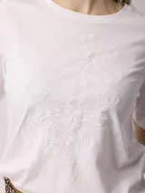 Remera azul marino de algodón con bordado floral en el frente.