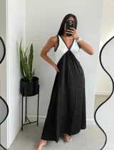 Vestido largo de corte amplio, con breteles finos y escote en V. La parte superior es blanca y la falda es negra.