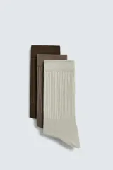 Pack de tres pares de calcetines de algodón acanalados en color marrón oscuro, marrón claro y beige.