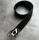 Cinturón negro de cuero con hebilla plateada con forma de letra D.