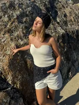 Bandana triangular tejida a crochet con hilo de algodón color marrón.