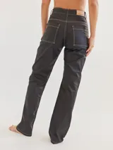 Pantalón jean negro de corte recto con costuras en color crudo.